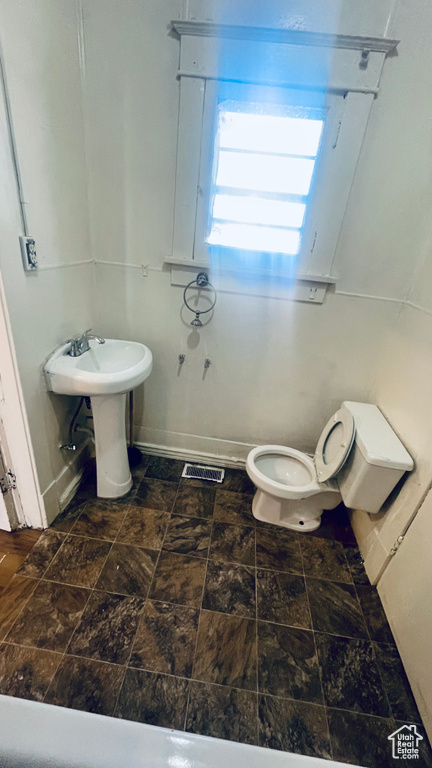 Bathroom featuring tile floors and toilet