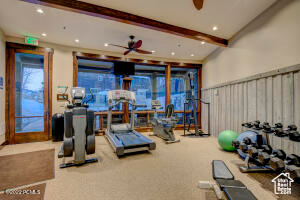Exercise room with light carpet and ceiling fan
