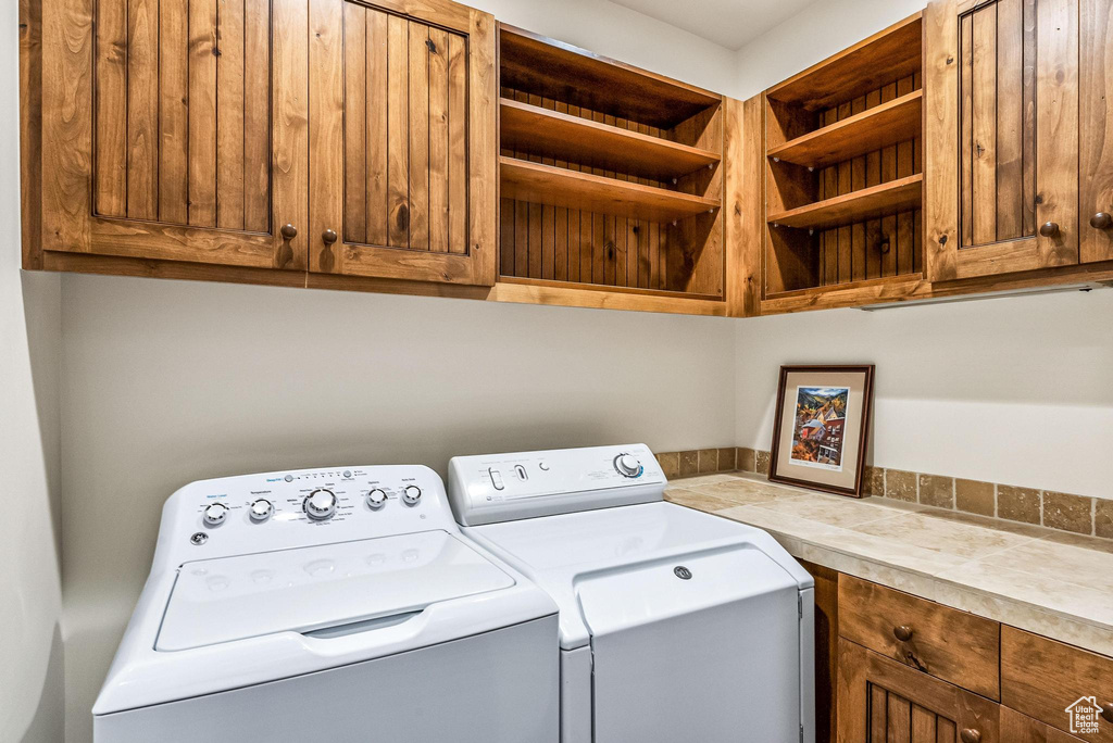 Clothes washing area with cabinets and washing machine and clothes dryer