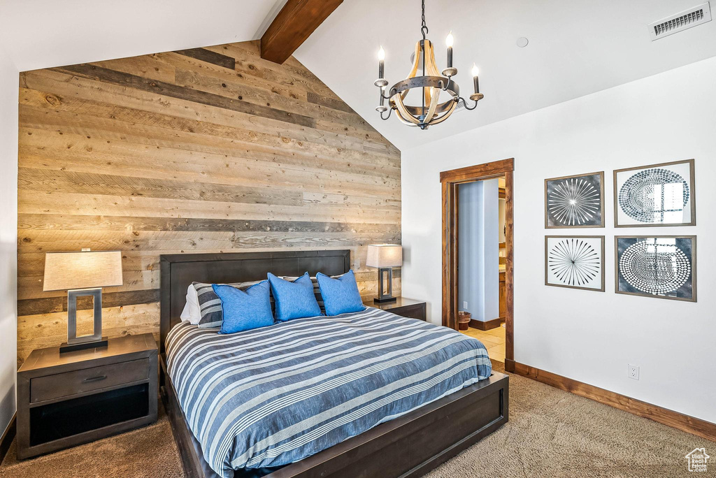Carpeted bedroom featuring a notable chandelier and vaulted ceiling with beams