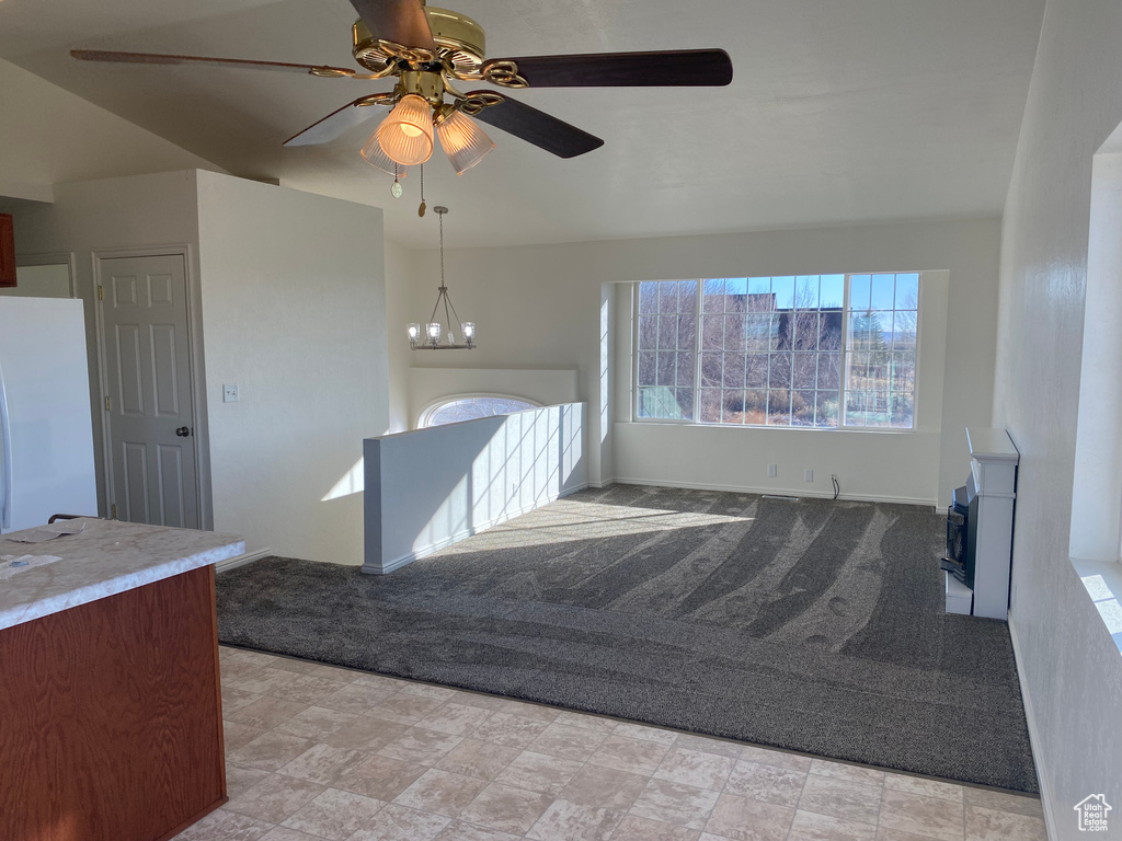 Interior space with ceiling fan with notable chandelier and white fridge