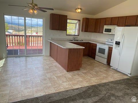 Kitchen with ceiling fan, light tile floors, white appliances, vaulted ceiling, and kitchen peninsula