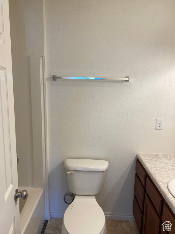 Full bathroom with vanity, toilet,  shower combination, and tile flooring