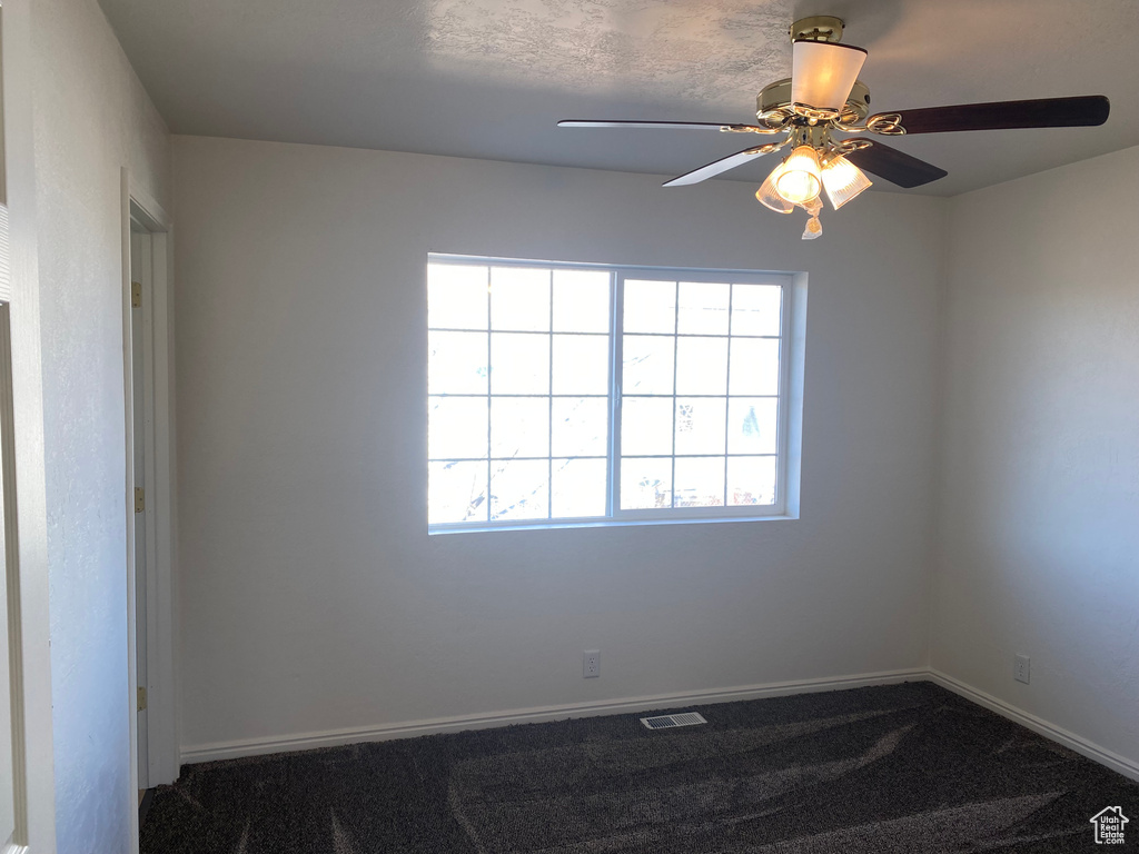 Carpeted empty room with ceiling fan