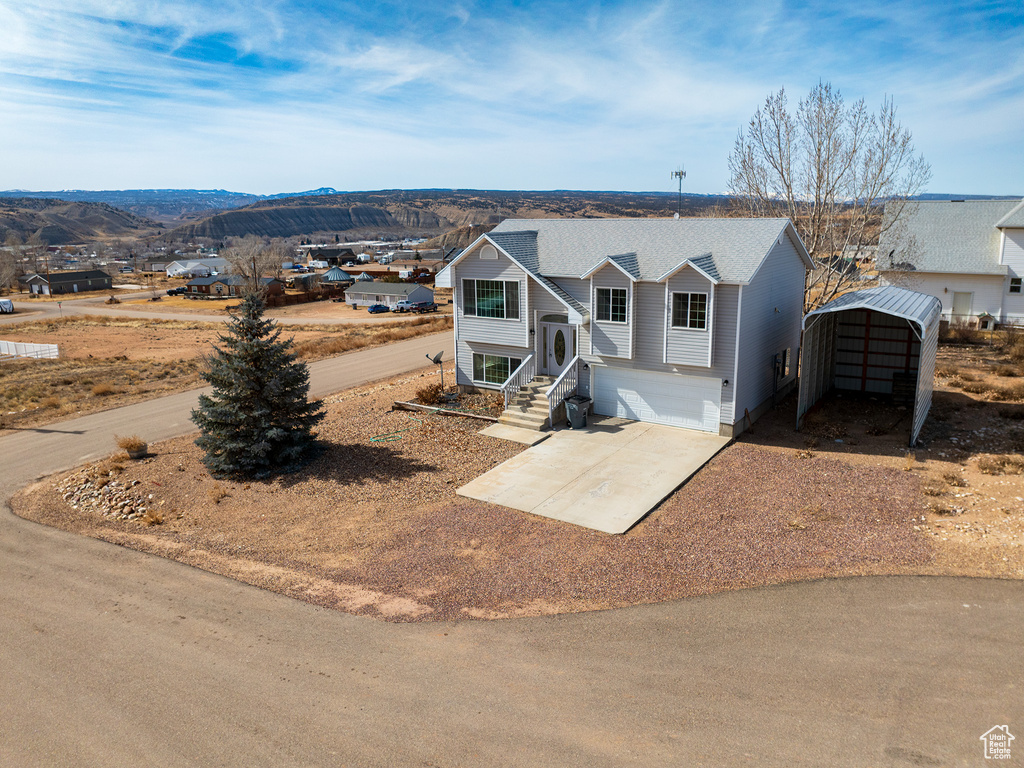 Bi-level home featuring a carport