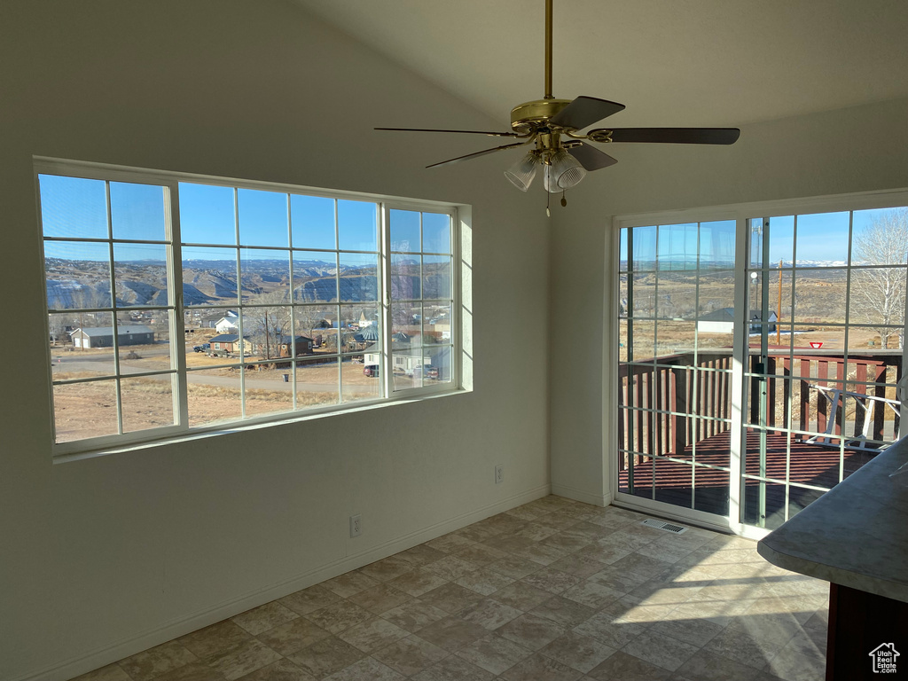 Unfurnished sunroom with a mountain view and ceiling fan