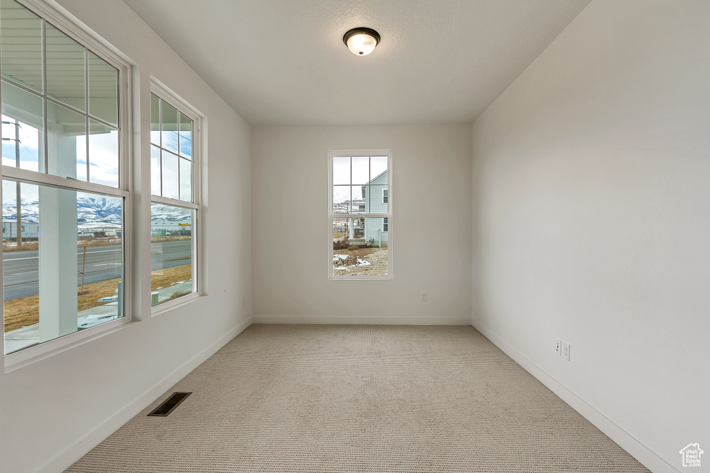 Empty room with plenty of natural light and light colored carpet