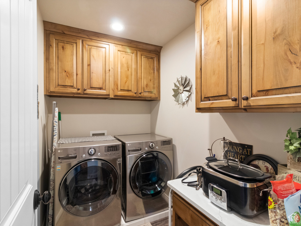 Washroom with washer and dryer and cabinets
