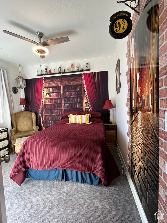 Bedroom featuring brick wall, ceiling fan, and dark carpet