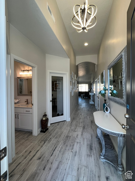 Corridor with a chandelier, hardwood / wood-style floors, and sink