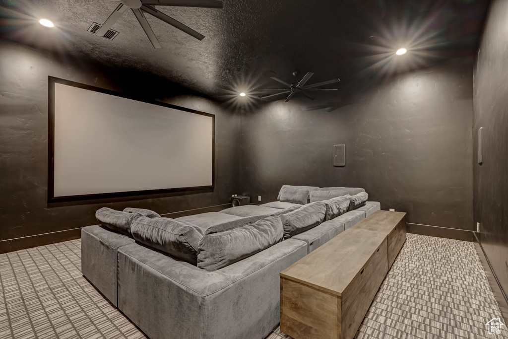 Tiled home theater featuring ceiling fan and a textured ceiling