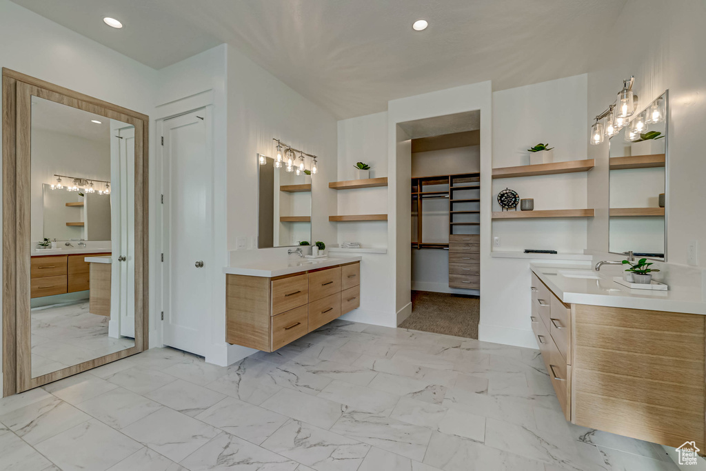 Bathroom featuring large vanity, dual sinks, and tile flooring