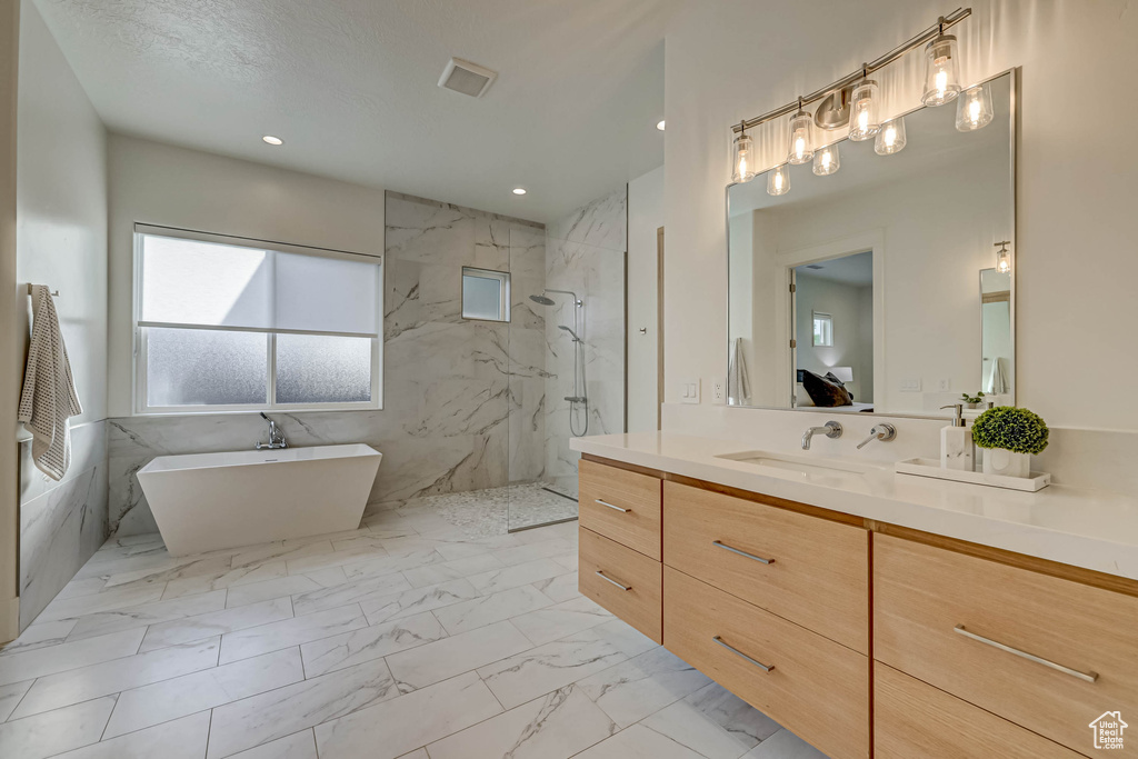 Bathroom featuring vanity, shower with separate bathtub, and tile flooring