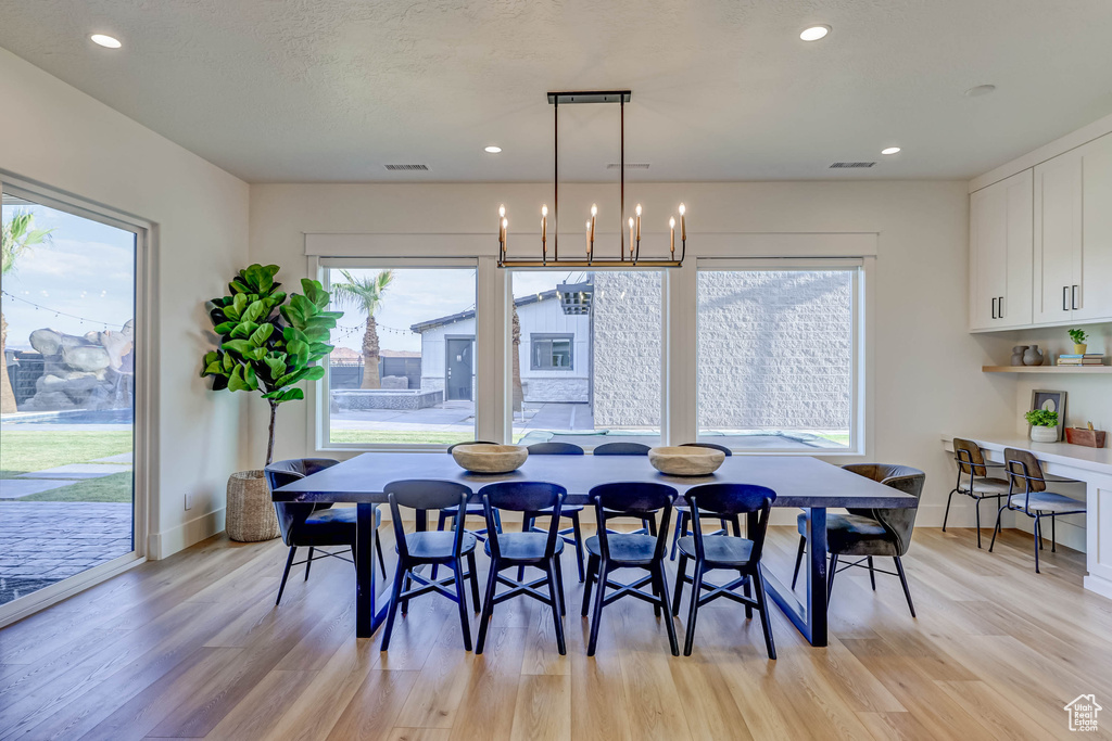 Dining space with a chandelier and light hardwood / wood-style floors