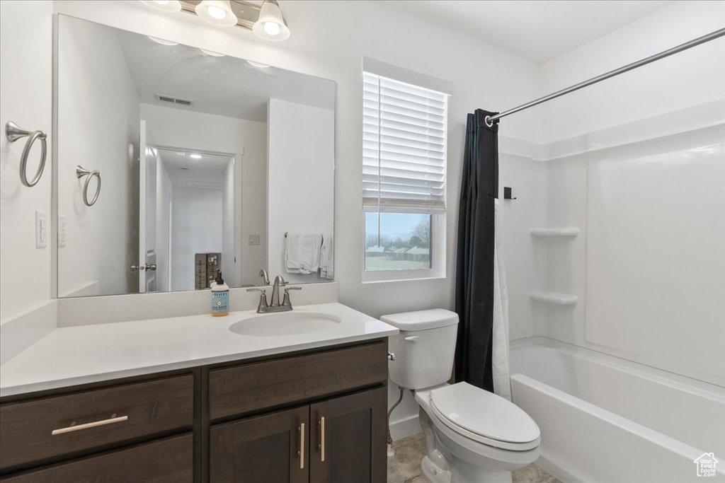 Full bathroom featuring tile flooring, shower / bath combo with shower curtain, toilet, and vanity