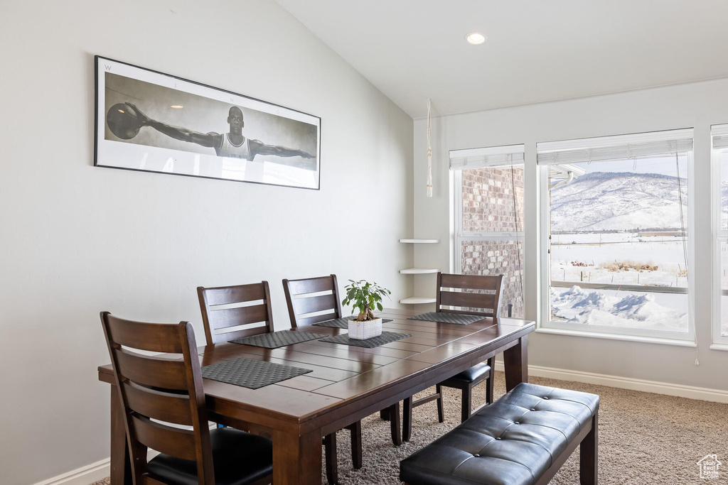 Carpeted dining area with a mountain view and lofted ceiling