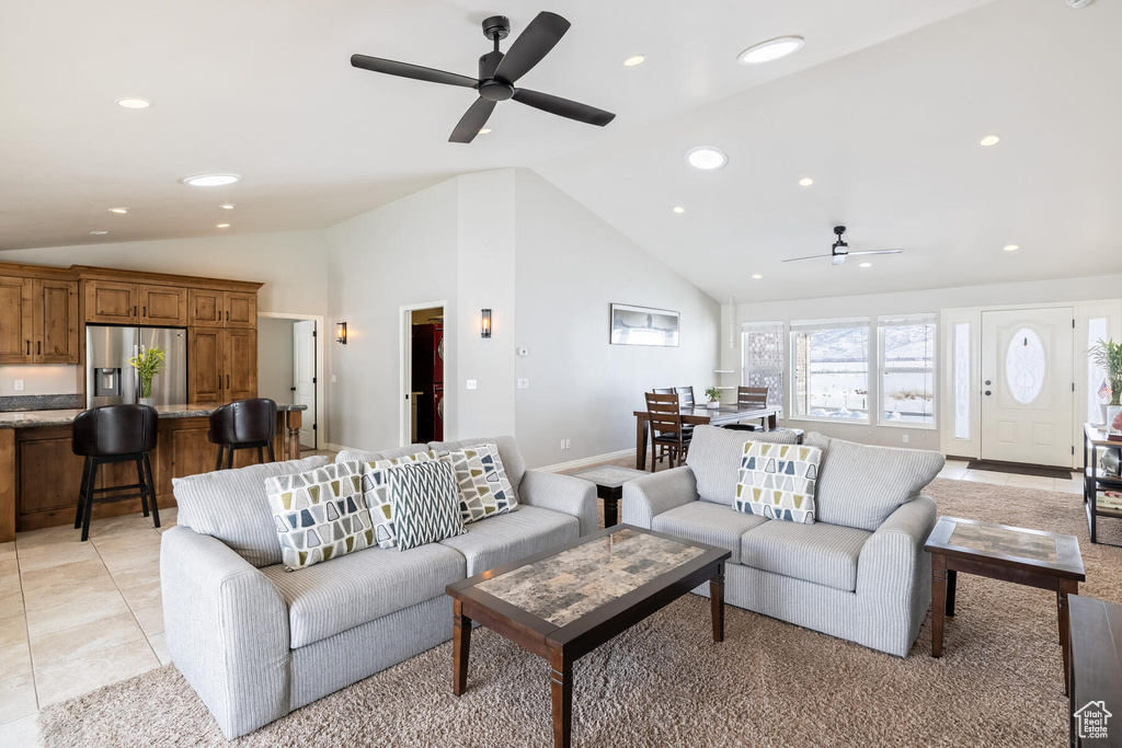 Tiled living room with ceiling fan and high vaulted ceiling