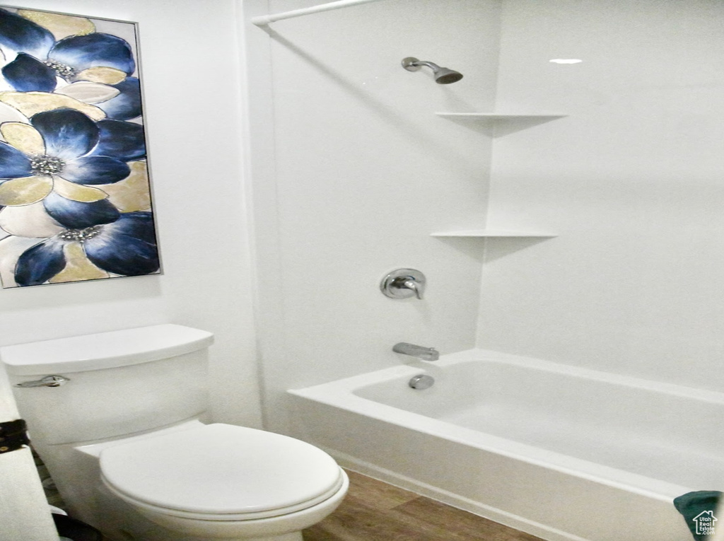 Bathroom featuring toilet, hardwood / wood-style floors, and shower / bathtub combination