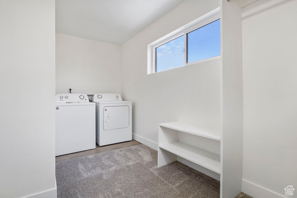 Washroom featuring hardwood / wood-style floors, washing machine and dryer, and washer hookup