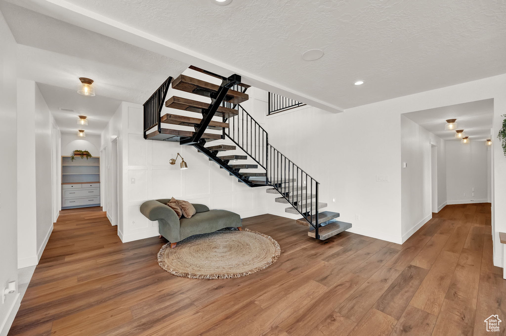 Stairway featuring wood-type flooring and a textured ceiling
