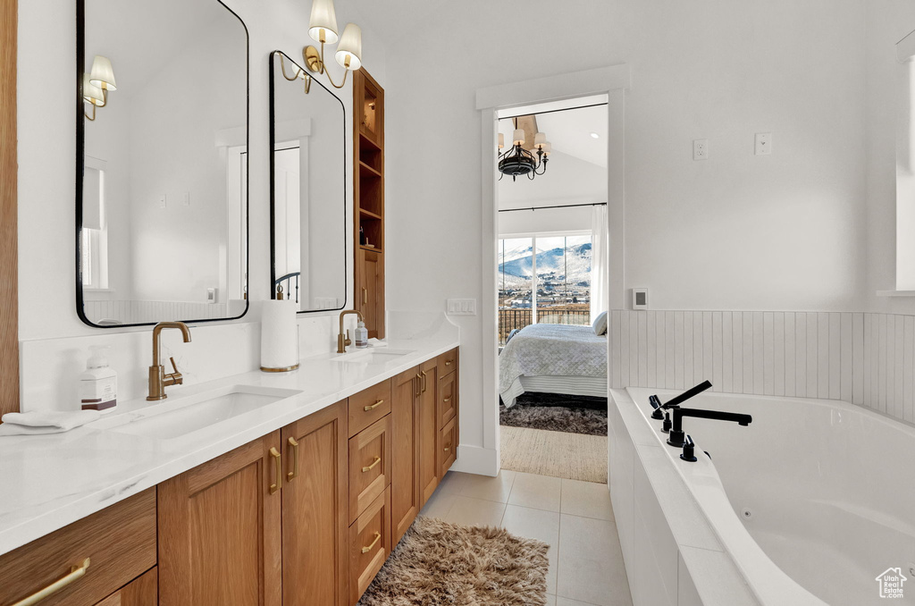 Bathroom featuring dual bowl vanity, tile flooring, tiled bath, and lofted ceiling