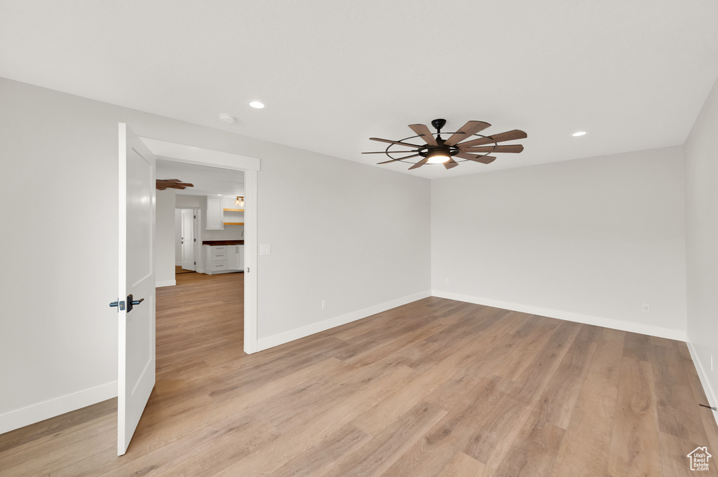 Unfurnished room with ceiling fan and light wood-type flooring