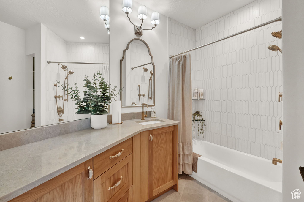 Bathroom featuring large vanity, shower / tub combo, and tile flooring