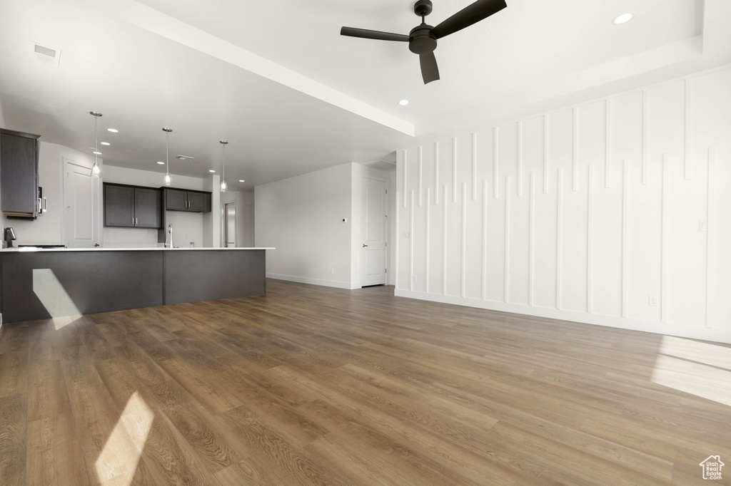 Unfurnished living room with ceiling fan and wood-type flooring