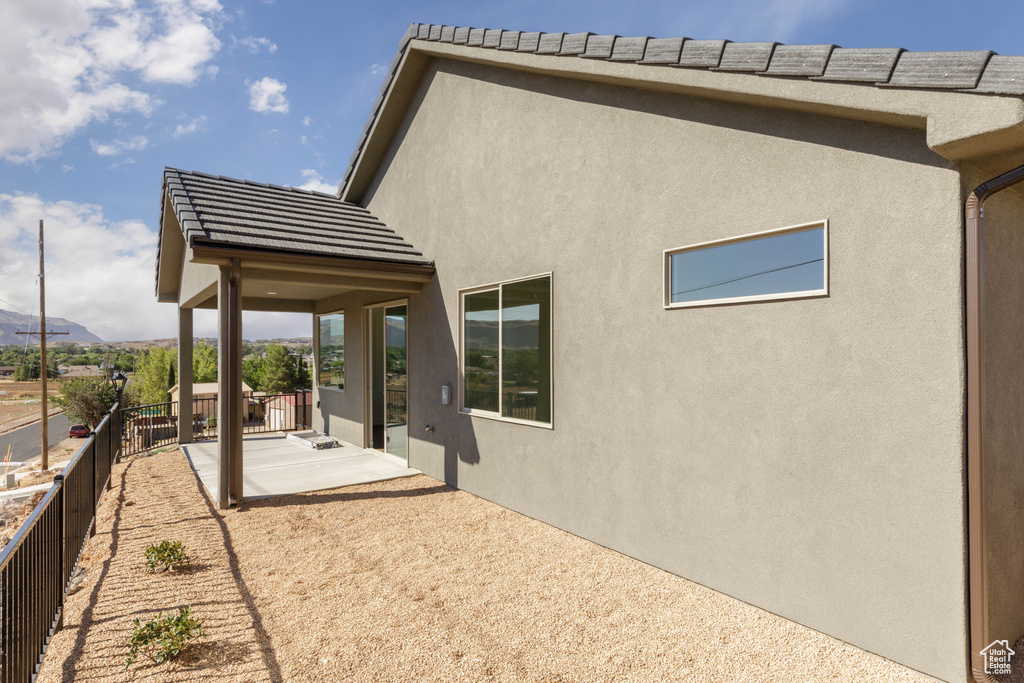 Rear view of property with a mountain view and a patio