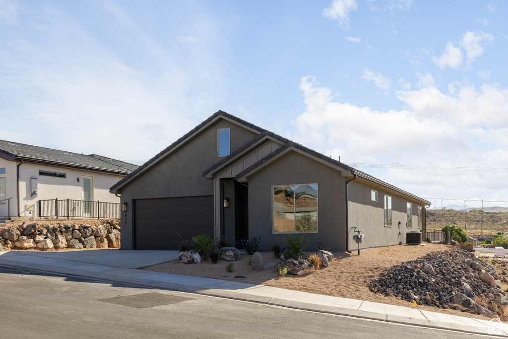 View of front of house with a garage and central AC unit