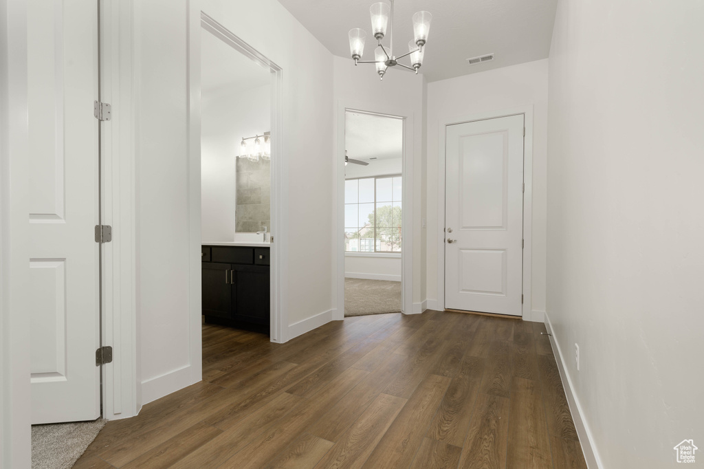 Interior space featuring dark wood-type flooring and a notable chandelier