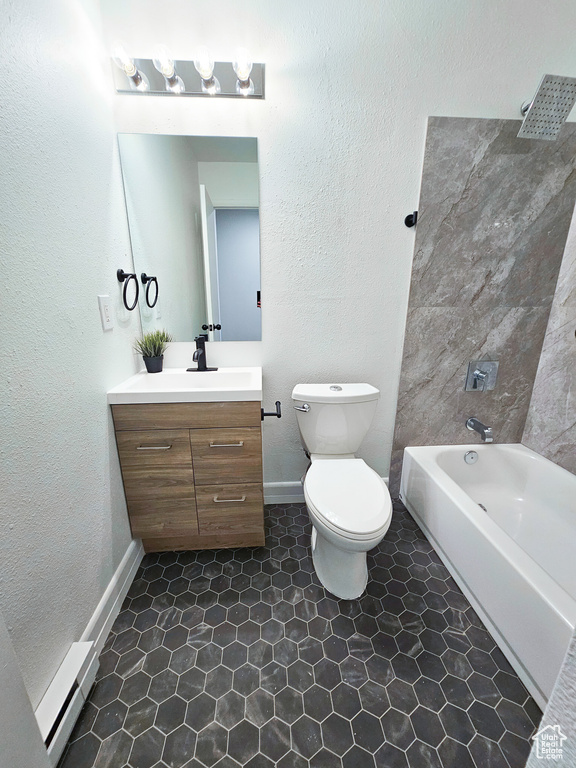 Full bathroom with toilet, a baseboard heating unit, large vanity, tile floors, and shower / bathing tub combination