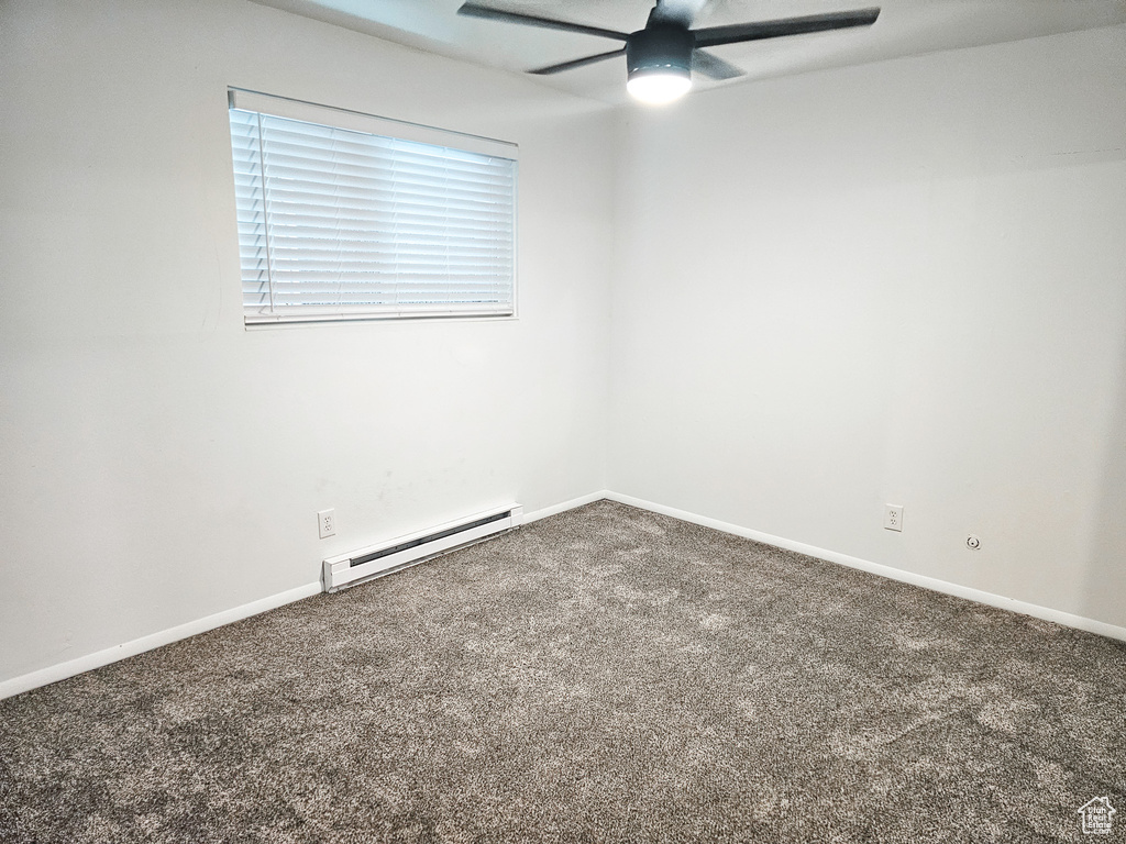 Carpeted spare room with a baseboard heating unit and ceiling fan