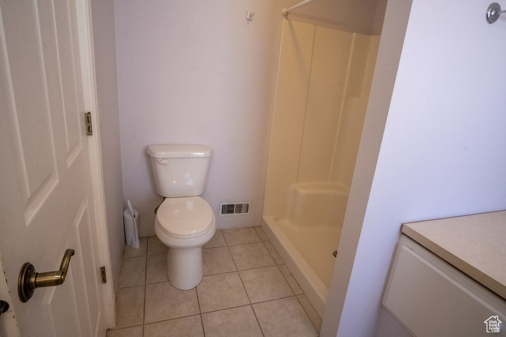 Bathroom with vanity, a shower, tile floors, and toilet