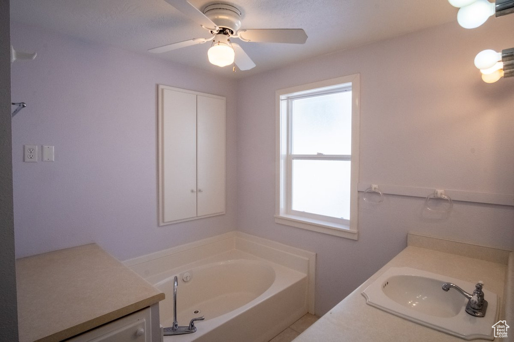Bathroom featuring plenty of natural light, vanity, and ceiling fan