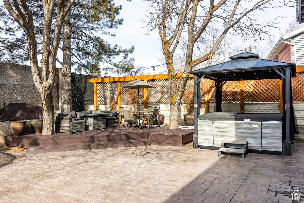View of terrace featuring an outdoor living space, a hot tub, and a gazebo