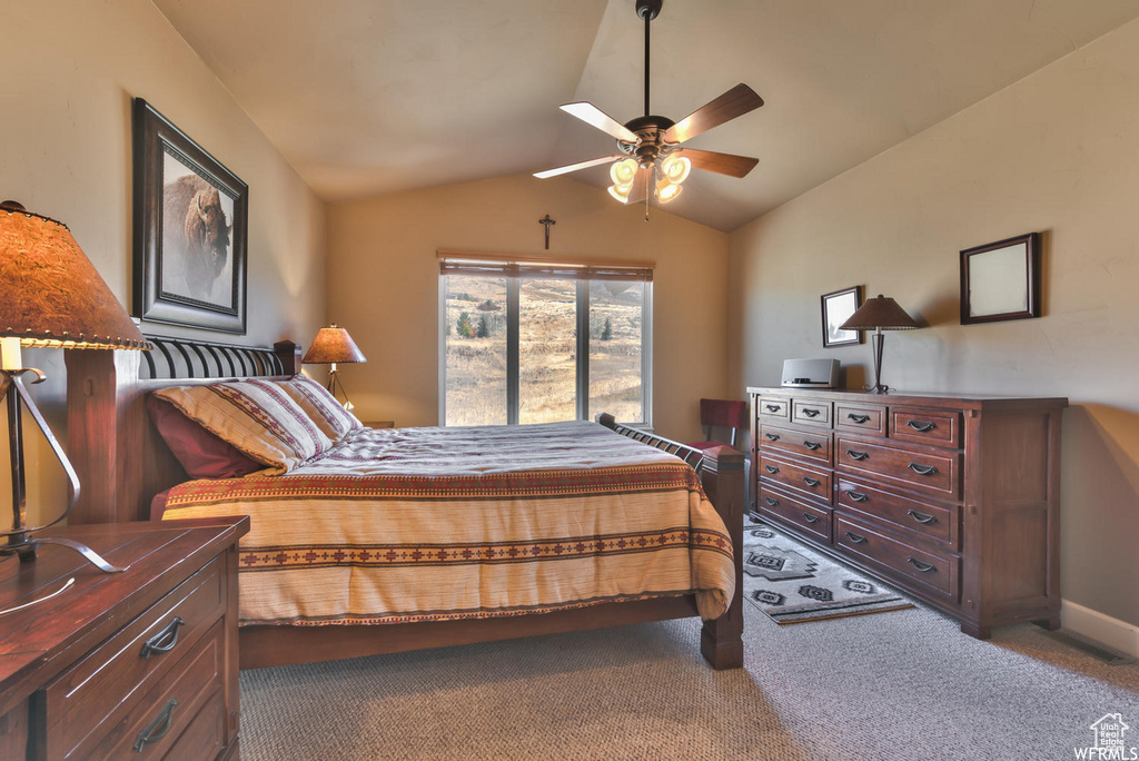 Bedroom with carpet floors, ceiling fan, and vaulted ceiling