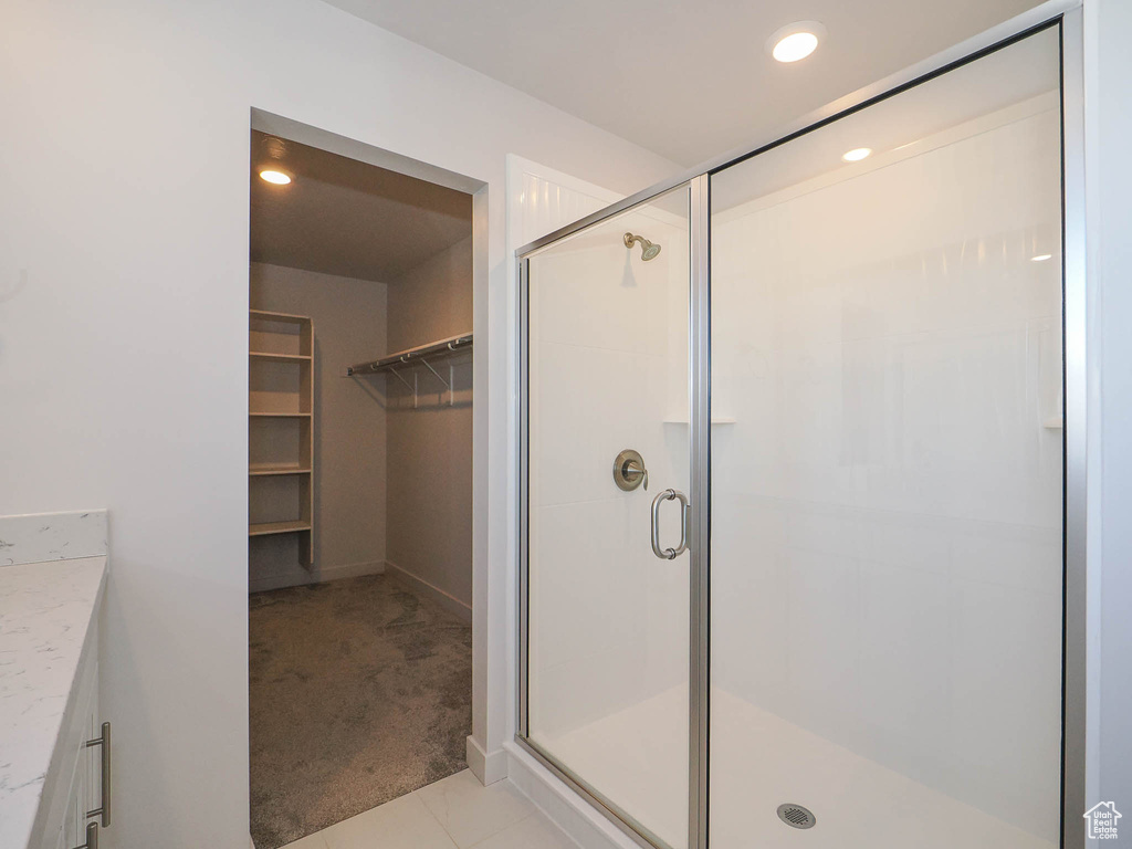 Bathroom featuring vanity, tile floors, and an enclosed shower