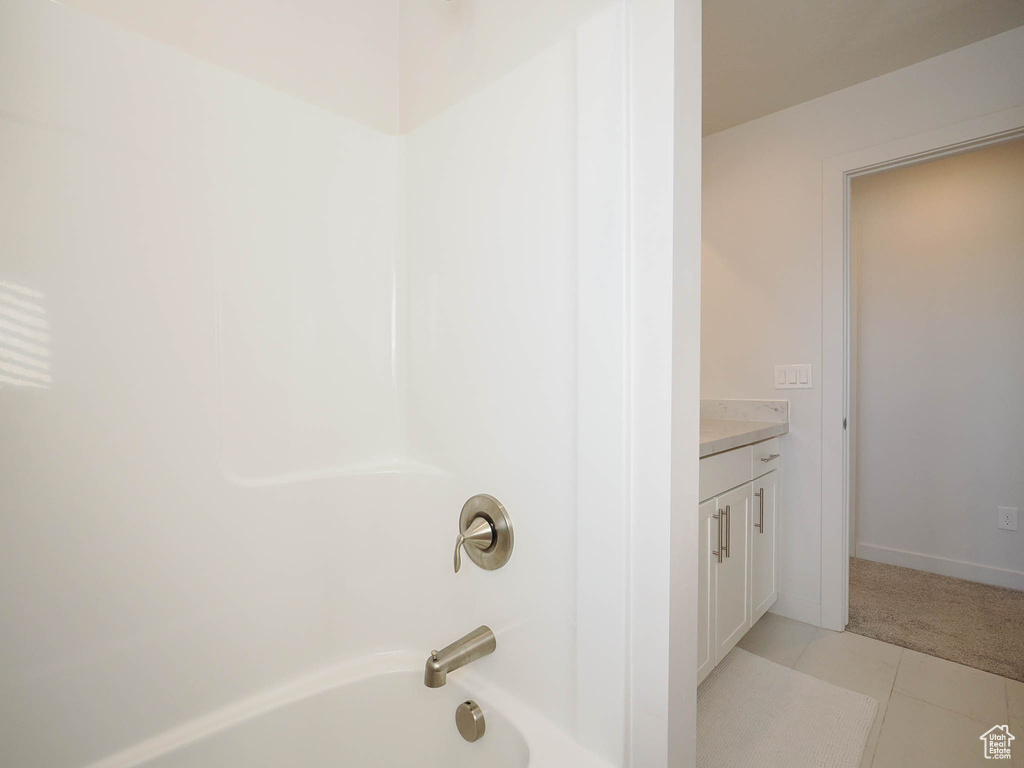 Bathroom featuring vanity, shower / bath combination, and tile floors