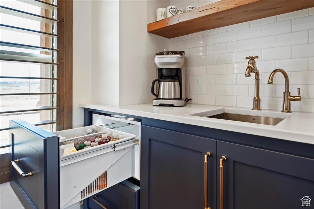 Kitchen with sink, backsplash, and blue cabinets