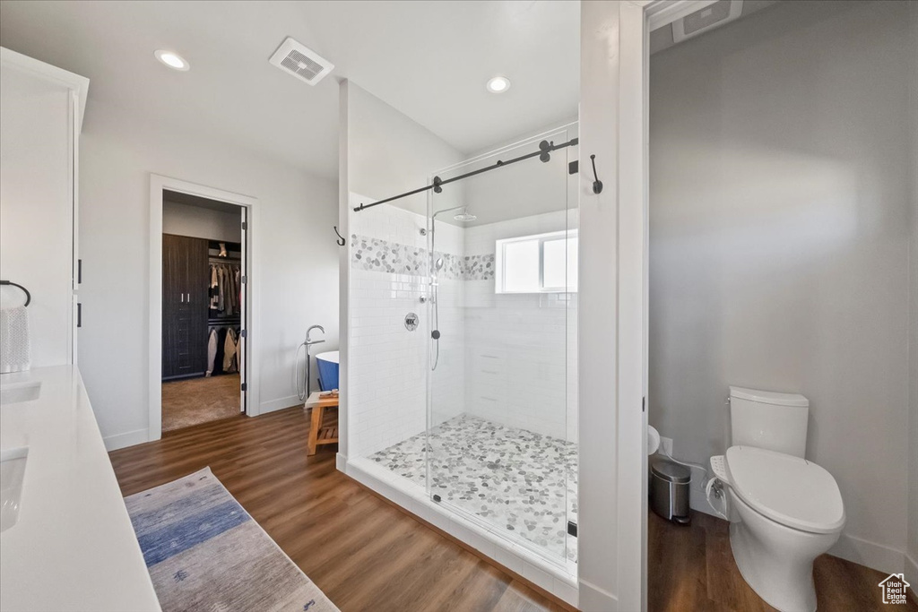 Bathroom with toilet, walk in shower, and wood-type flooring