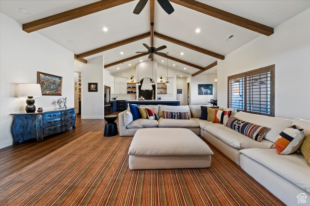 Living room with hardwood / wood-style floors, beamed ceiling, ceiling fan, and high vaulted ceiling