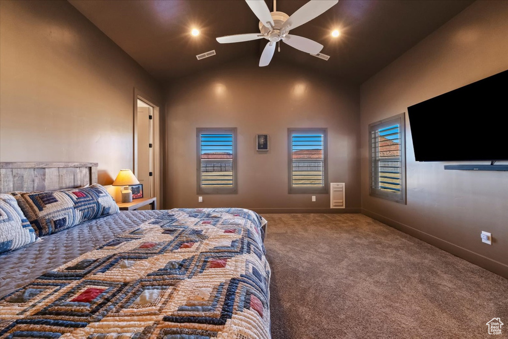 Bedroom featuring dark colored carpet, high vaulted ceiling, and ceiling fan