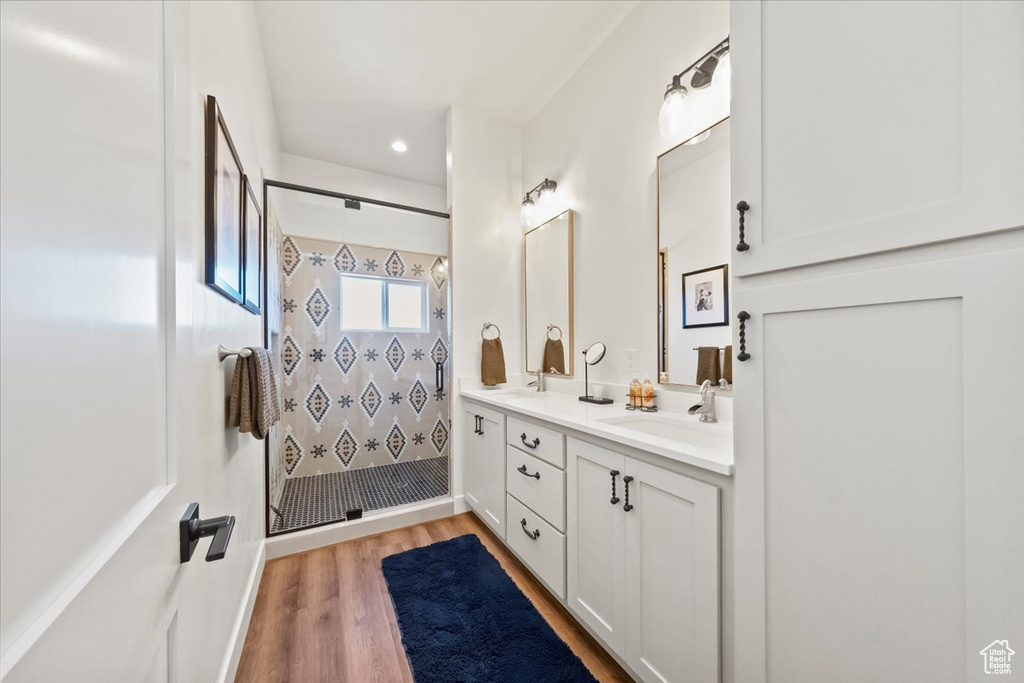 Bathroom with vanity, hardwood / wood-style flooring, and tiled shower