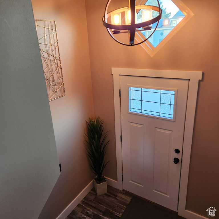 Entrance foyer featuring an inviting chandelier and dark hardwood / wood-style floors