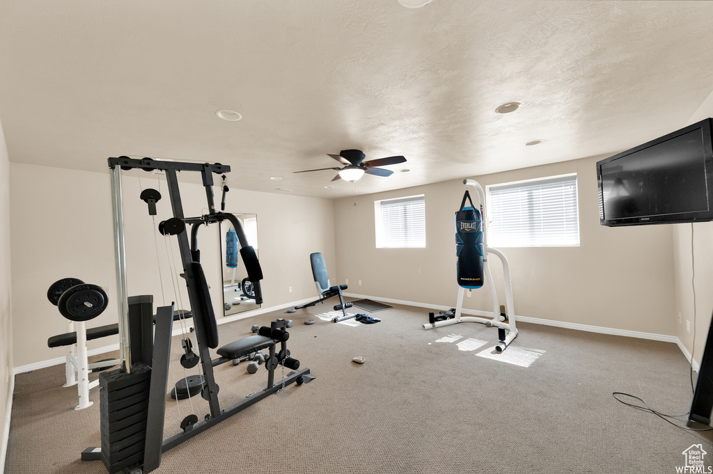 Exercise area featuring ceiling fan and light colored carpet