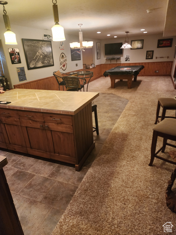 Kitchen featuring a kitchen bar, tile counters, dark tile flooring, and billiards