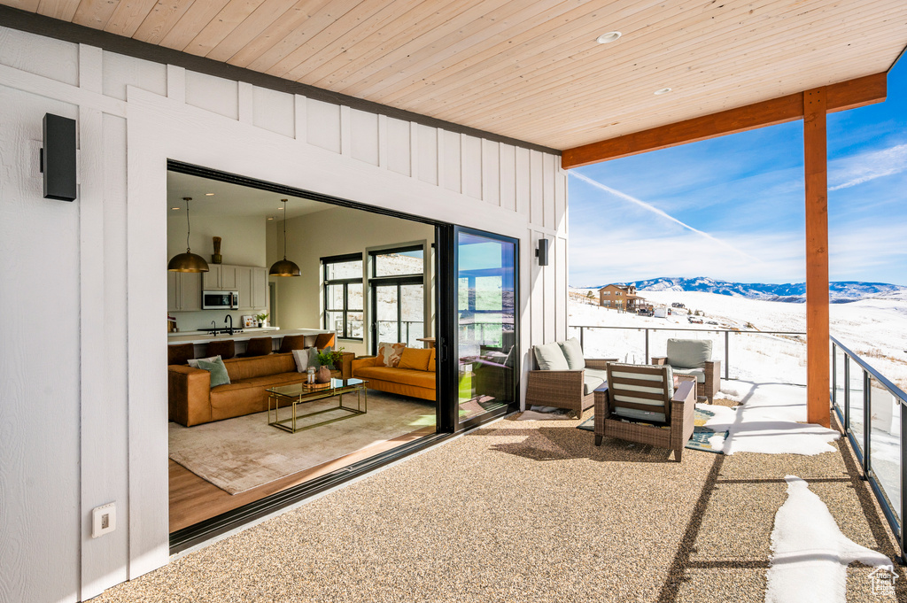 Snow covered patio featuring outdoor lounge area and a mountain view