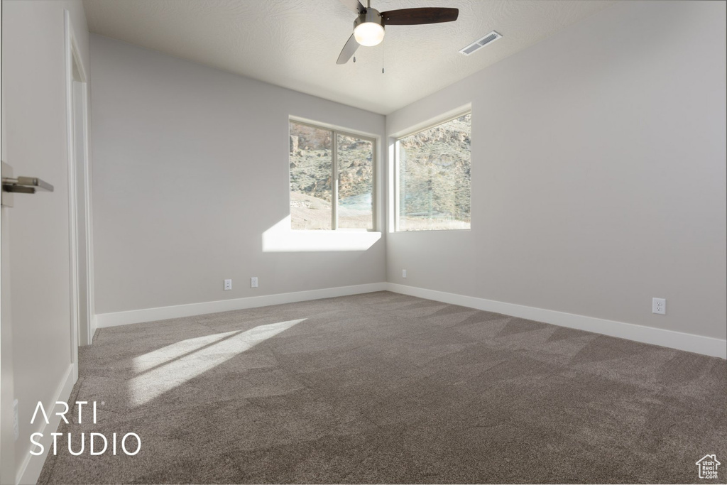 Spare room featuring ceiling fan and carpet