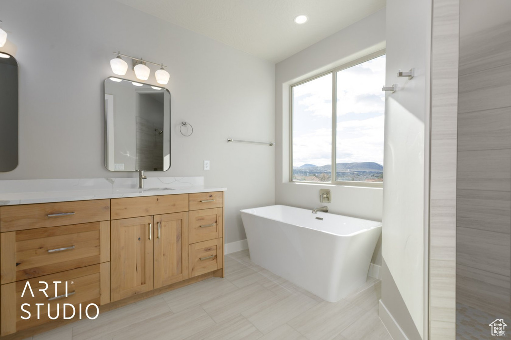 Bathroom with vanity, a bath, and tile flooring